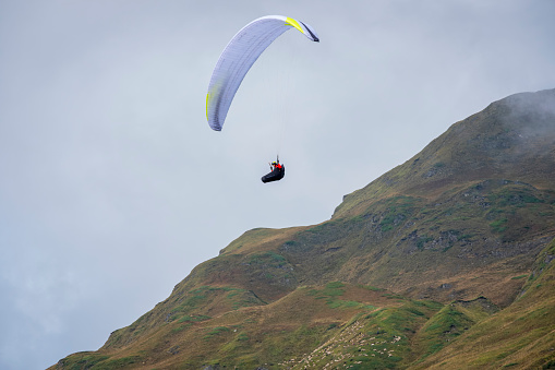 Paraglider is flying over the mountains around the village of La Frua. It's located at extreme northern side of Piedmont (Northern Italy), at the border between Italy and Switzerland.