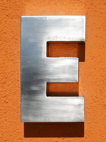 3D metallic E letter over orange background