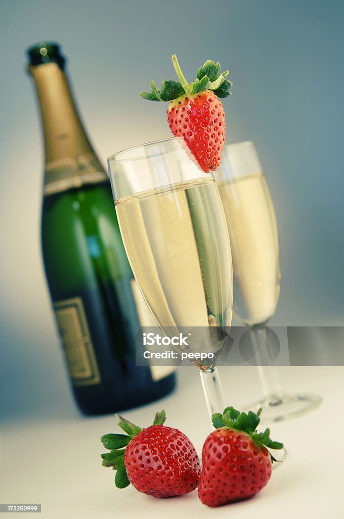 champagne "cross processed image of bottle of champagne, two full glasses and strawberries - shallow depth of field" Alcohol - Drink Stock Photo