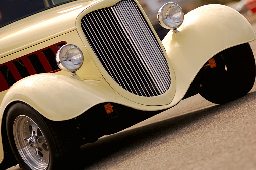 A view of a fender and head lamp of a classic updated vintage automobile