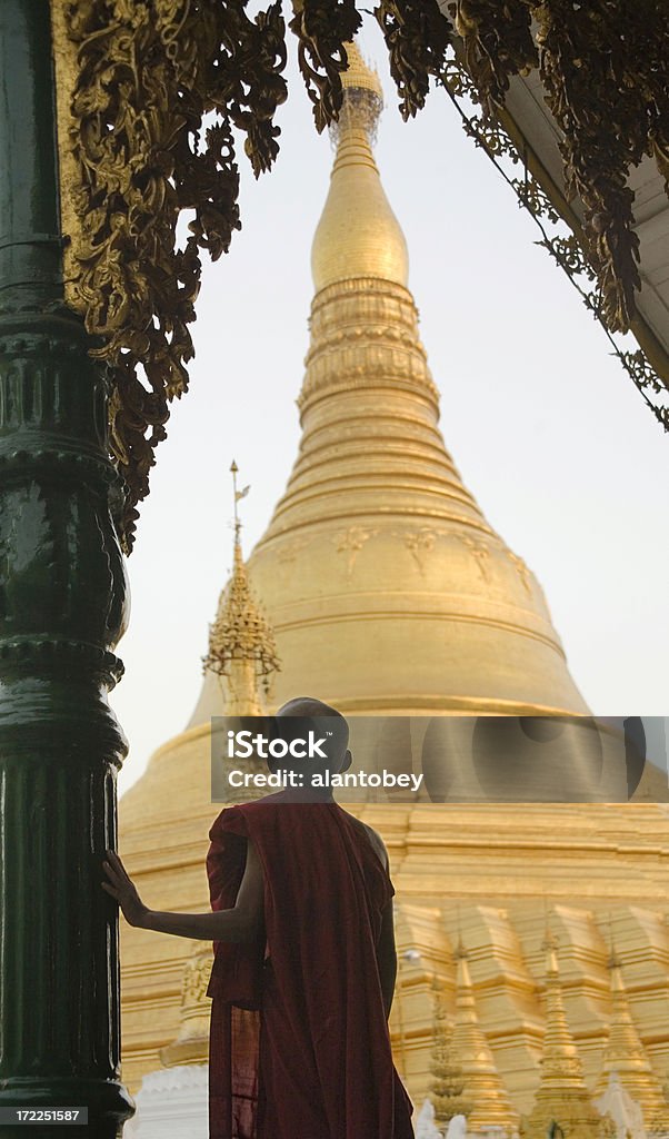 Yangon, Myanmar: Shwedagon Pagoda and Monk in Evening Light "Yangon, Myanmar: Shwedagon Pagoda and Monk in Evening Light.More photos of Myanmar religious structures in my lightbox at http://www.istockphoto.com/my_lightbox_contents.phplightboxID=1674710" Buddhism Stock Photo