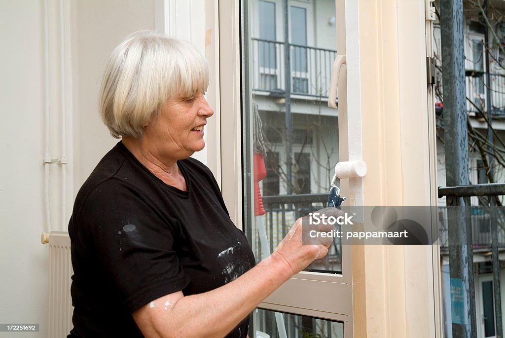 Sênior mulher Pintando uma porta 2 - Foto de stock de 60 Anos royalty-free
