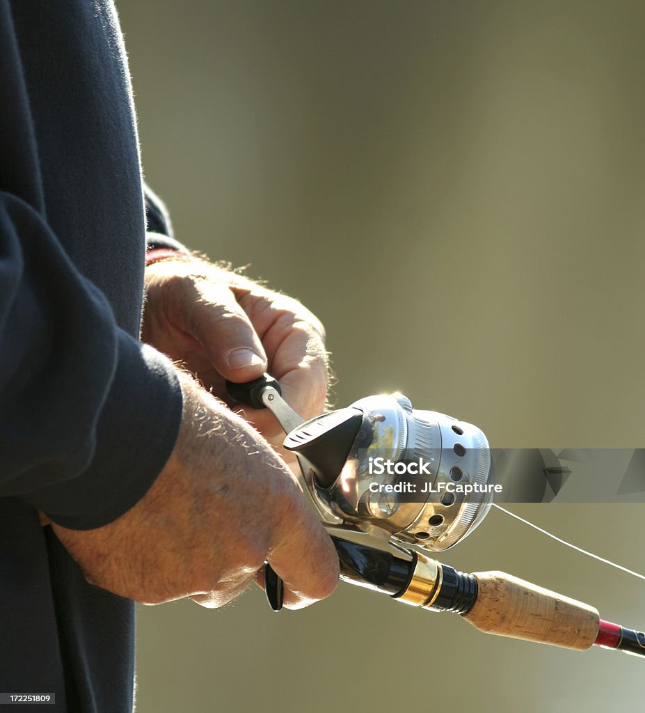 Fishing Hands a closeup of a man's hands using a rod and reel and fishing on a sunny afternoonPlease take a look at my other fishing photos: Activity Stock Photo