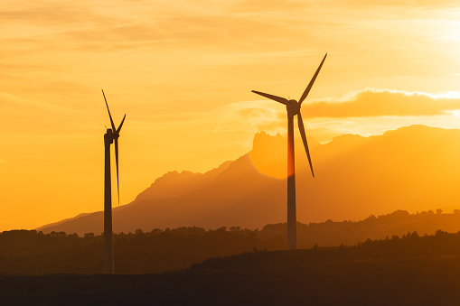 Orange wind farm sunrise in Navarre (Spain) with copy-space. Sustainable development, environment friendly, renewable energy concept.