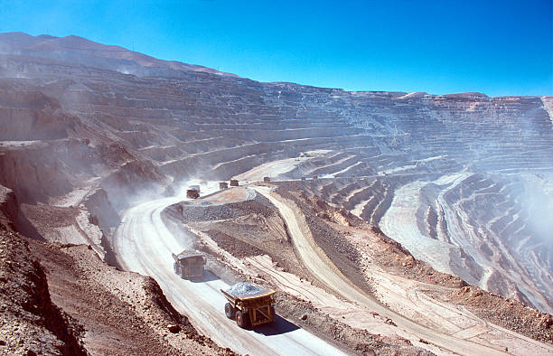 Ore trucks in an open-pit mine Ore trucks in an open-pit mine. Calama, Atacama desert. North Chile copper mine photos stock pictures, royalty-free photos & images