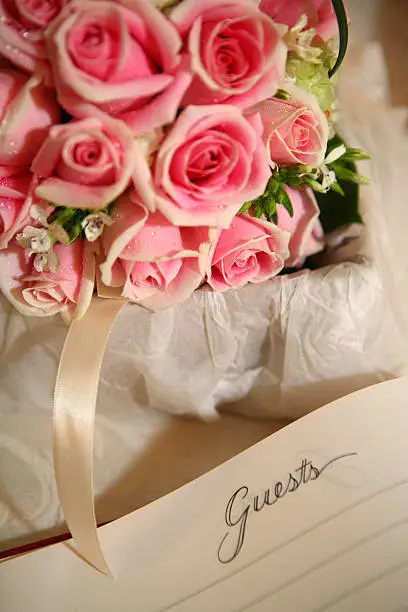 A bunch of pink rose with a guestbook.