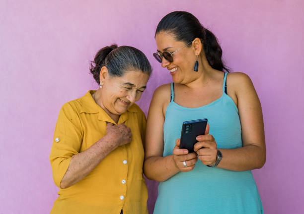 istock two women while one shows the other one something on her mobile phone 1722530644