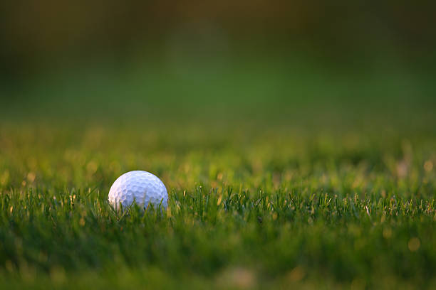 White Golf ball on a beautiful golf course next to a note