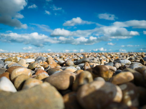 Shallow focus of large stones seen on a deserted beach. The stones are used as part of coastal defences in the east of the UK.