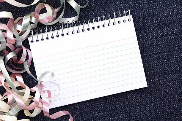 blank notepad on denim with ribbons stock photo