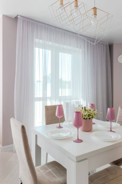 istock A modern living room combined with a kitchen, in light colors. Dining table with pink tableware 1722537295