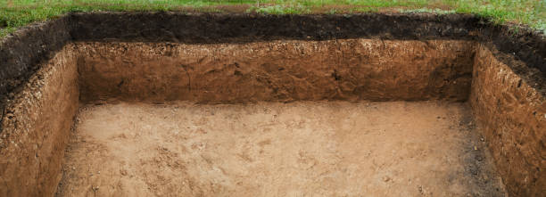 Image of hole in the ground. Soil layer in section. Slice of layers of different structures. stock photo