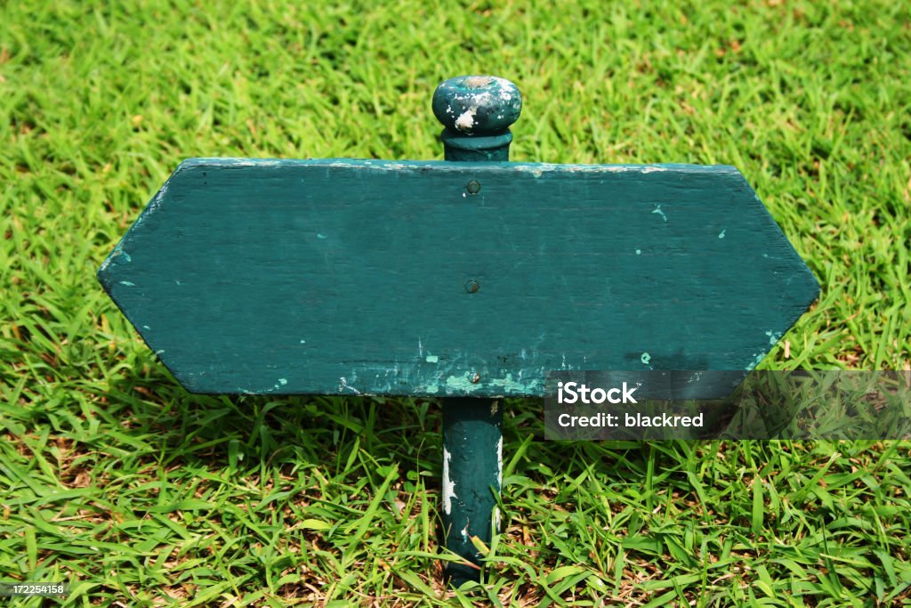 Wooden Sign on a Lawn Close-up of a blank wooden signage on a lawn.Similar images - Advertisement Stock Photo