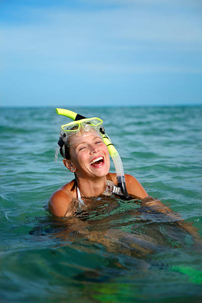 smiling snorkel woman in the water stock photo