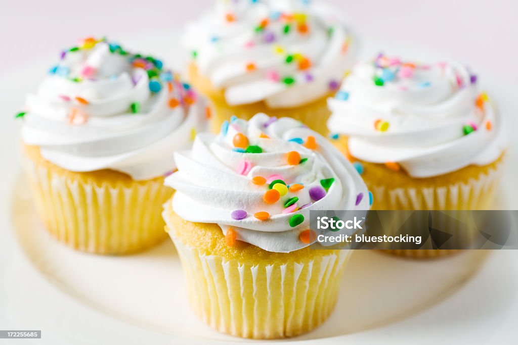 Four yellow cake and white frosted cupcakes with confetti Cupcakes with white frosting swirls and colorful confetti. Shallow DOF. Cupcake Stock Photo Four yellow cake and white frosted cupcakes with confetti Cupcakes with white frosting swirls and colorful confetti. Shallow DOF. Cupcake Stock Photo