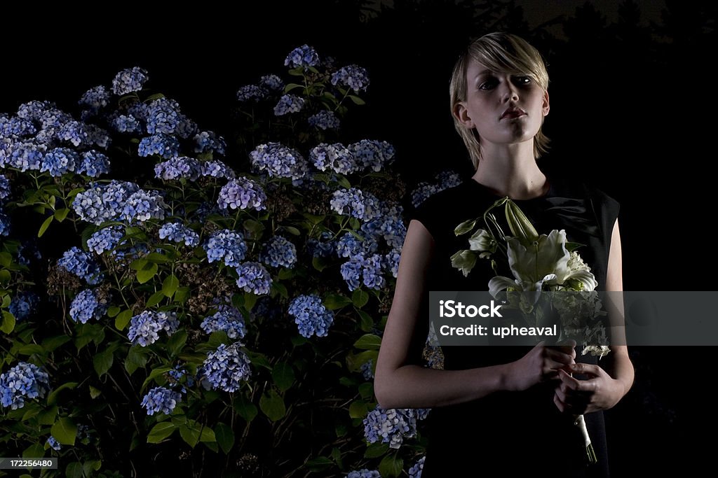 Funeral Portraits Mourning widow with flower arrangement. Adult Stock Photo