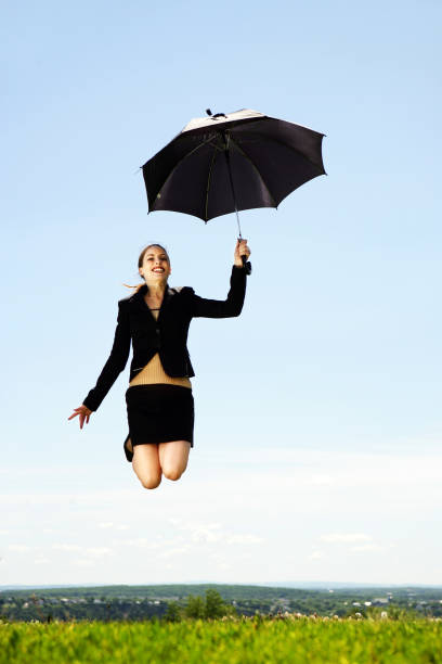 istock Woman jumping holding an umbrella 172256590