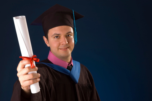 Portrait of young man with disability at graduation ceremony in university, copy space
