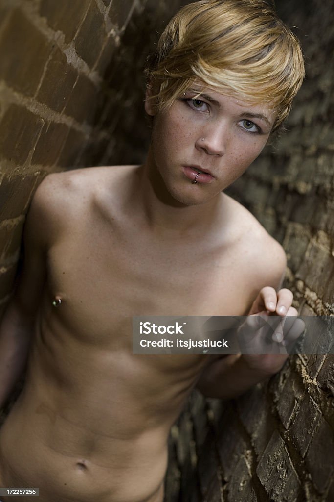 Emerging from the darkness. Teen male coming out of a dark alley. Teenage Boys Stock Photo