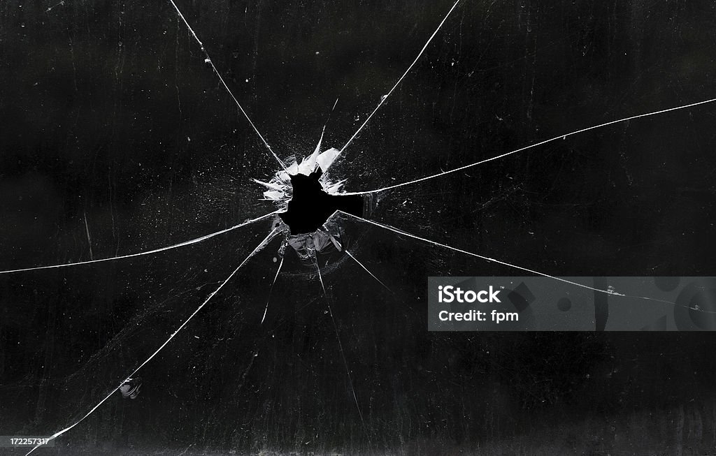 A bullet hole in a glass window Bullet hole in dirty glass Shattered Glass Stock Photo