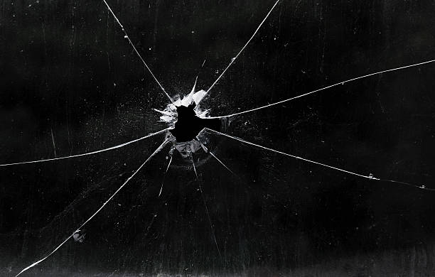 A bullet hole in a glass window Bullet hole in dirty glass shooting a weapon photos stock pictures, royalty-free photos & images