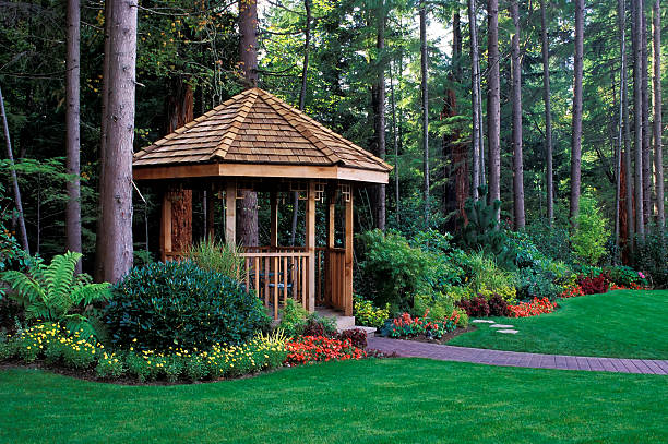 A beautiful backyard garden with a cedar wood gazebo cedar gazebo backyard garden pavilion photos stock pictures, royalty-free photos & images