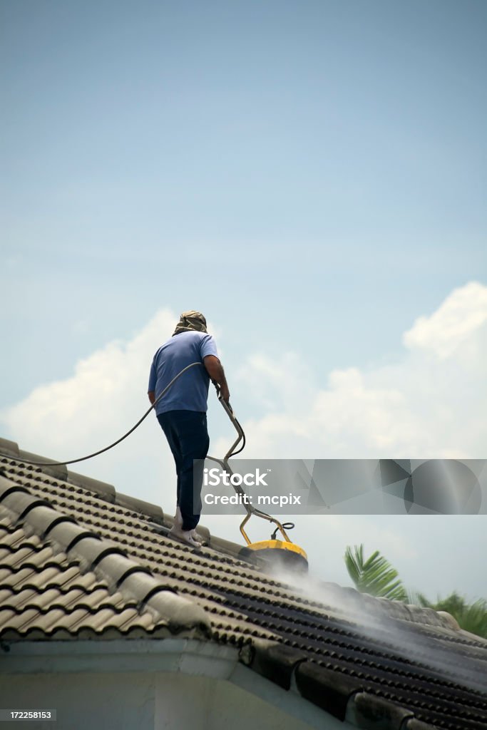 Pressure Cleaner Pressure cleaning a roof. Rooftop Stock Photo