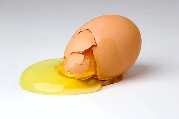 A broken egg with the yoke spilling out