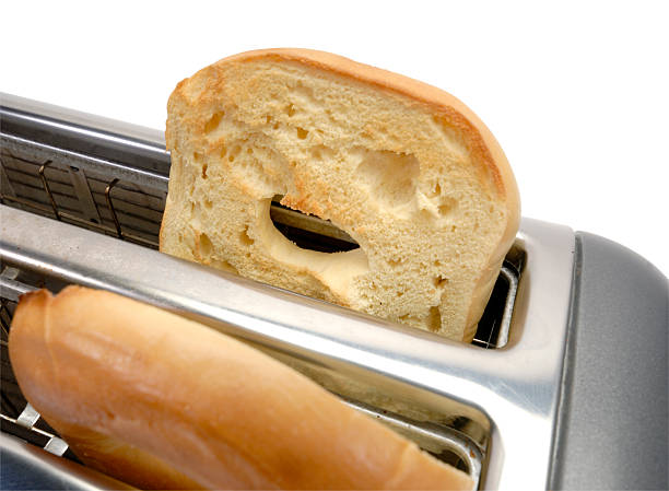 Woman using toaster to prepare breakfast at home
