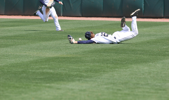 an outfielder diving and missing a ball