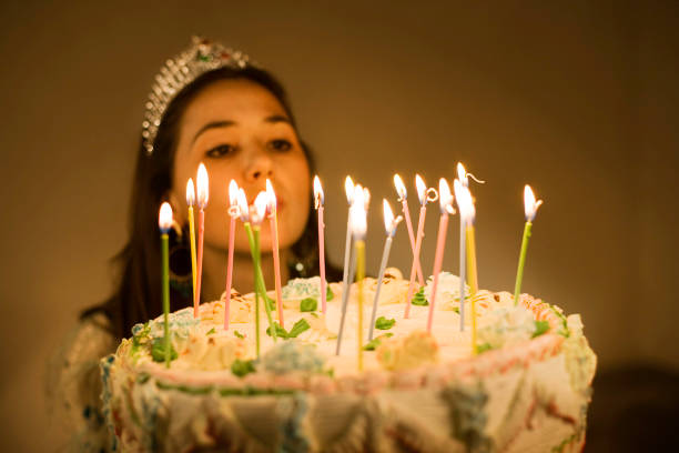 Wish Land Woman blowing the candles of her birthday cake. quinceanera stock pictures, royalty-free photos & images