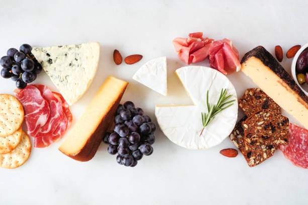 Charcuterie table scene on a white marble background