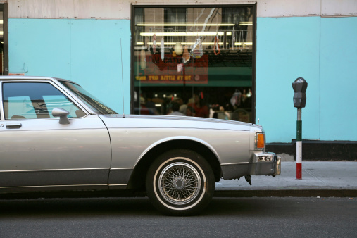 An old sedan car parked outside an Italian delicatessen in Little Italy, New York City, New York, USA.
