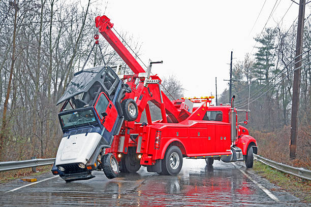 Car Crash Recovery on Rainy Day "The car has just been lifted out of the river. It is still raining lightly, and you can see this in the full size image. This is a special wrecker truck with a boom to lift cars from places an ordinary tow truck can't get to. More images in my portfolio." terryfic3d stock pictures, royalty-free photos & images