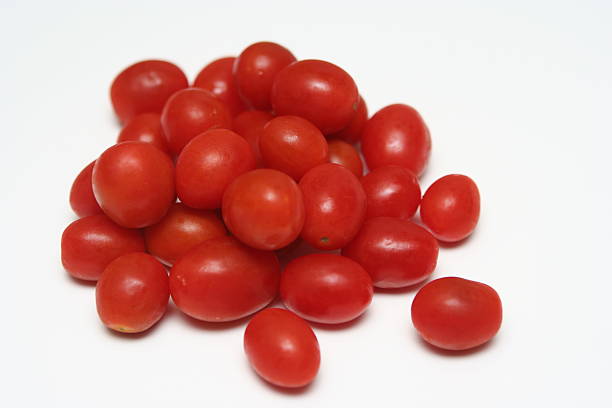 Tomatos Close up of grape tomatoes on a white background. grape tomato stock pictures, royalty-free photos & images