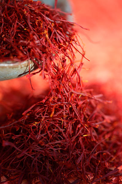 Red saffron 2. Estigmas of Crocus sativus falling from an earthen bowl. saffron stock pictures, royalty-free photos & images