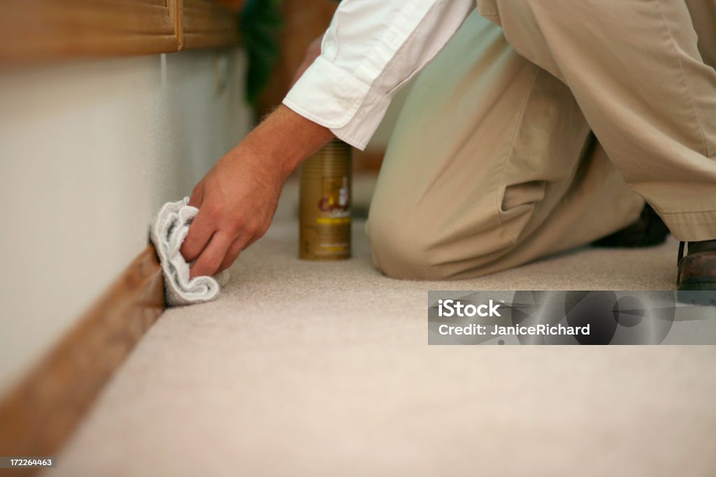 Baseboard Cleaning Carpet cleaner cleaning the baseboard of a home. Baseboard Stock Photo