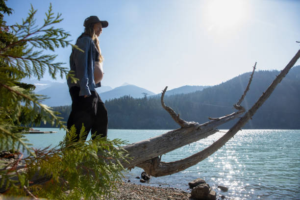 jovem se equilibra e caminha ao longo de tronco, à beira do lago - stone wellbeing zen like blue - fotografias e filmes do acervo