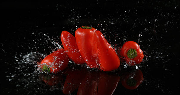 istock Red Sweet Peppers, capsicum annuum, Vegetable falling on Water against Black Background 1722662035