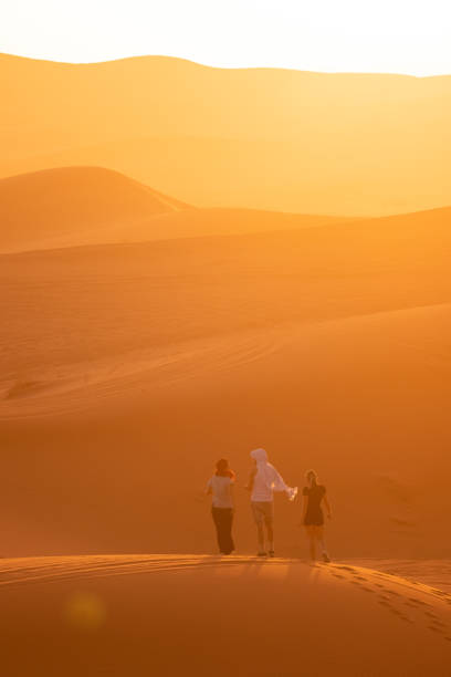 istock Friends walks across sand dunes, at sunrise 1722664906