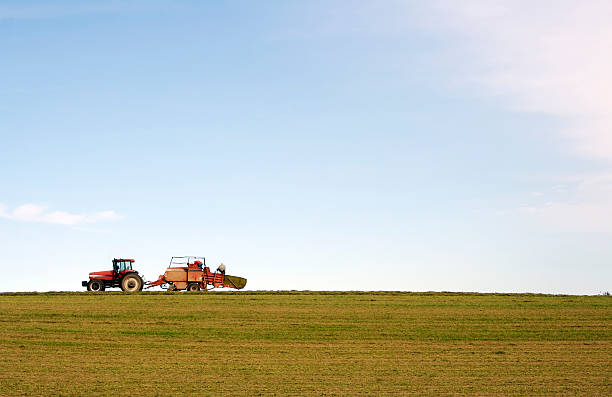 Bailing hay in a field with tractor
