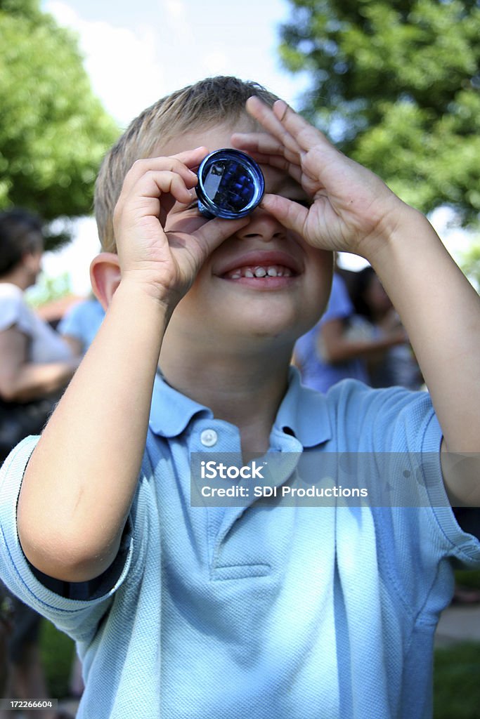 Jeune garçon regardant à travers un jouet Kaleidescope - Photo de Kaléidoscope - Jouet libre de droits