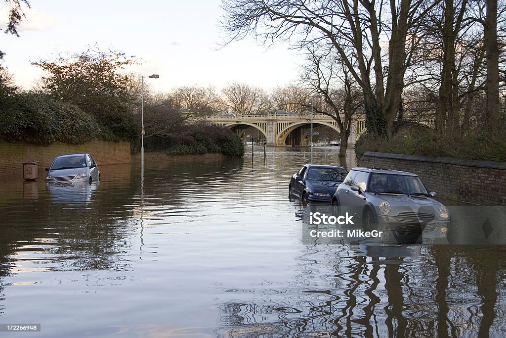 Flooded road near Richmond, London A Spring high tide floods a Richmond street leaving cars waterlogged. Flood Stock Photo