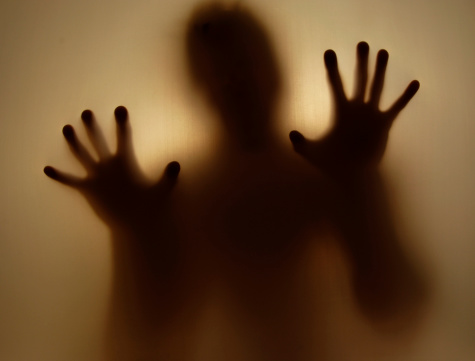 grunge image of blurred figure holding up hands