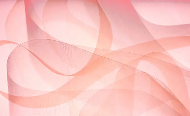 Pink ribbons swirl around in an abstract background.