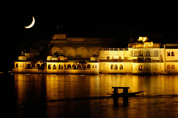 Udaipur Lake Palace at night Udaipur Lake Palace at night with double exposure of the moon lake palace stock pictures, royalty-free photos & images