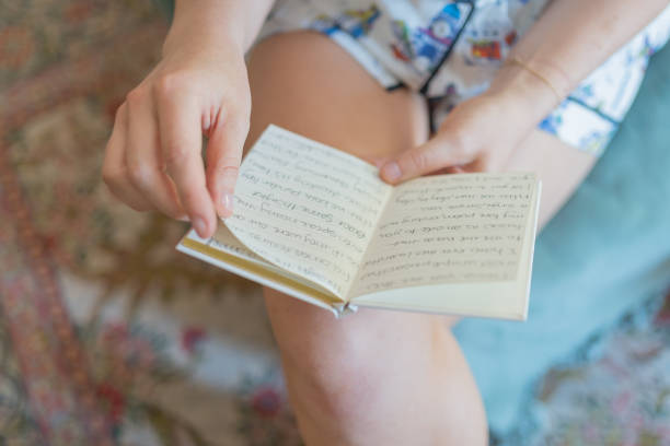 istock Young woman reads from handwritten  book 1722685019