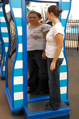 A woman examines herself in a fun house mirror.  Here is a link to my other self esteem photos.