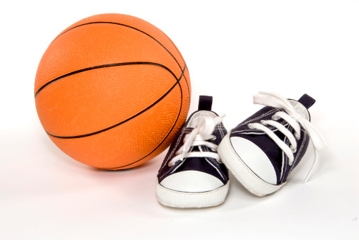 child sneakers and a basketball on white background
