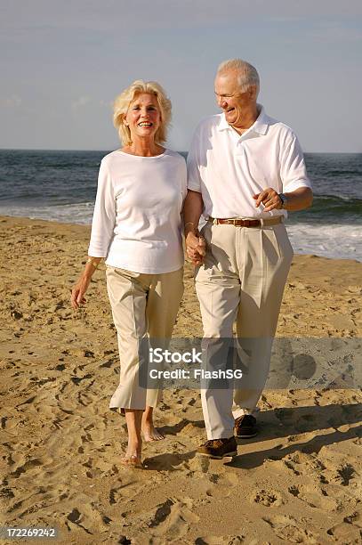 Senior Pareja Caminando En La Playa Foto de stock y más banco de imágenes de Actividades y técnicas de relajación - Actividades y técnicas de relajación, Andar, Felicidad